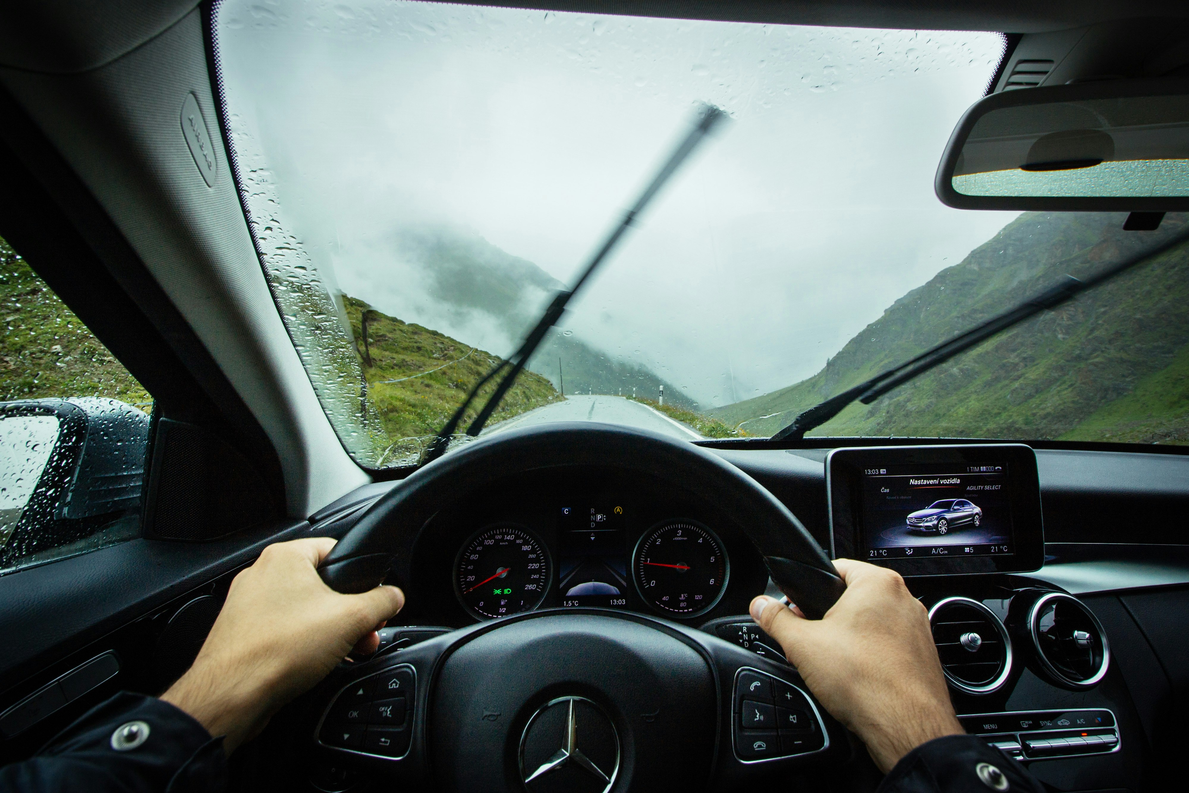 person driving Mercedes-Benz car during daytime